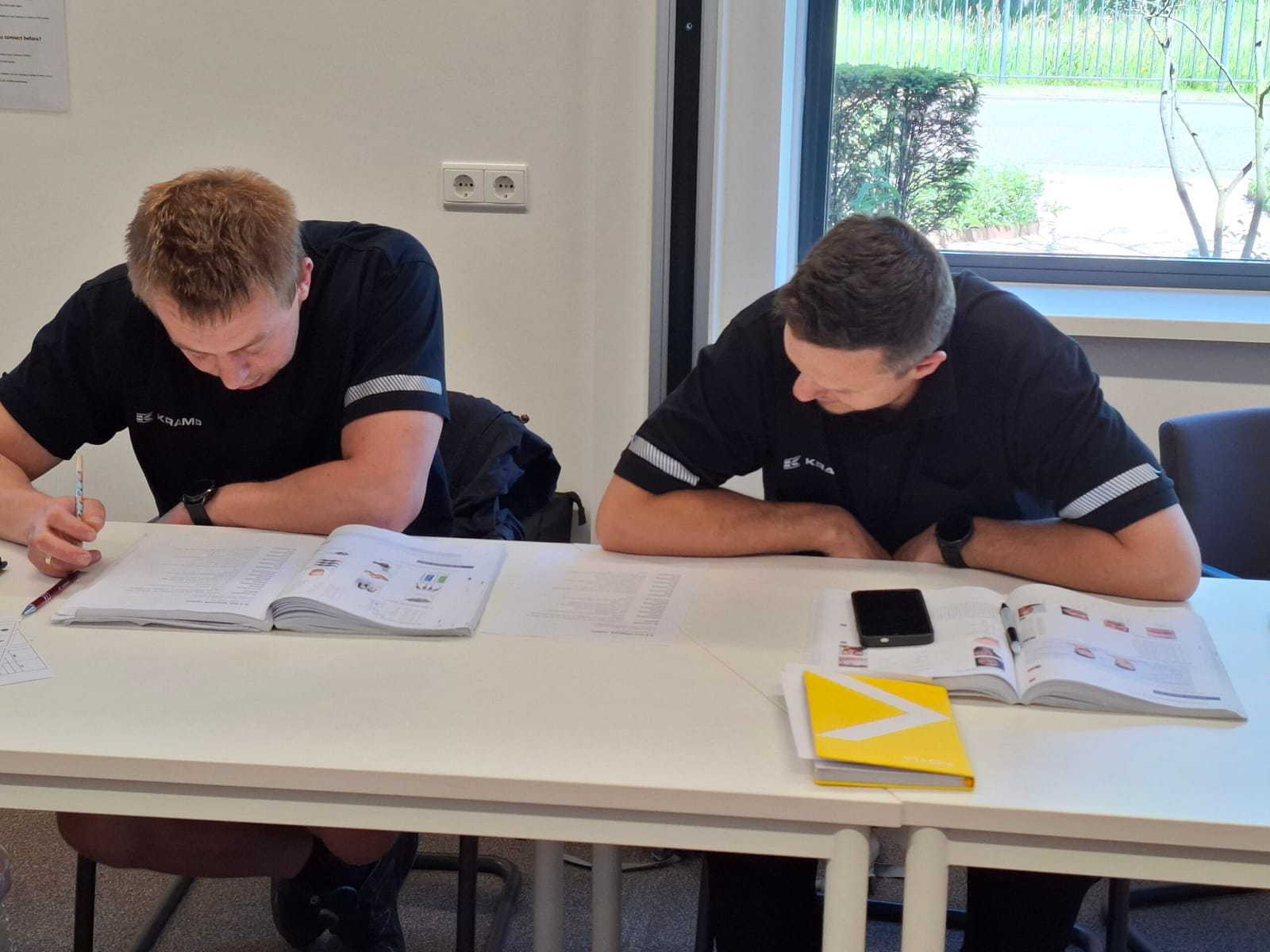 Twee medewerkers werken samen in een werkboek